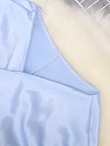 Close-up of light blue satin top showing premium stitching and silky fabric texture
