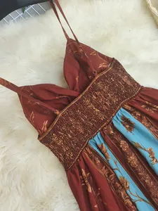 Close-up of vintage floral print maxi dress showing smocked back and straps.