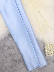 Macro view of light blue satin fabric texture and stitching detail on women's top