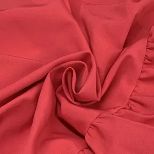 Detailed close-up of the red fabric texture and ruffled seam on a puff sleeve midi dress