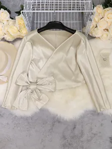 Elegant champagne satin wrap top with a side bow detail and long sleeves