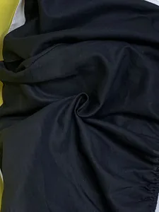 Detailed macro view of black cotton linen fabric showing natural woven texture quality