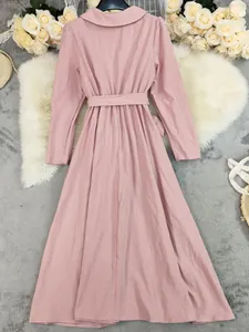 Detail of a pink long-sleeved cotton linen maxi dress with a waist tie