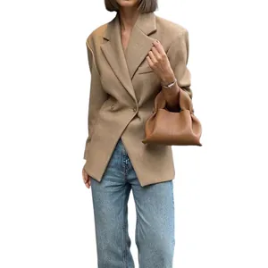 Schicker Business-Look mit schmalem Kamel-Blazer, Jeans und einer Lederhandtasche