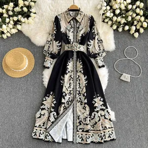 Robe chemise longue élégante noire à imprimé paisley avec ceinture assortie présentée.