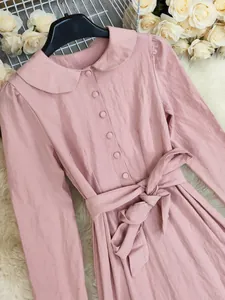 Detail of a pink cotton linen maxi dress featuring a Peter Pan collar and waist tie