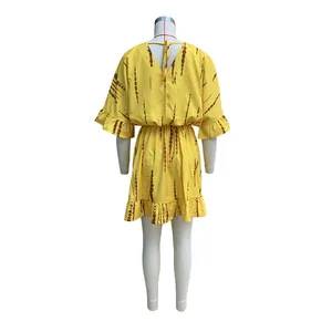 Vista posteriore di miniabito bohémien giallo con strisce tie-dye marroni e volant trendy