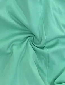 Detailed macro view of soft mint green jersey fabric texture for women's summer jumpsuit