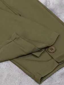 Close-up detail showing the buttoned cuff and fine stitching of olive green suit pants.