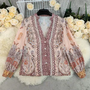 Close-up view of bohemian style blouse with intricate floral and paisley print details.
