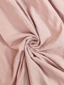 Macro shot of soft pink cotton linen fabric showing natural texture and breathable weave