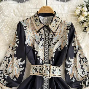 Détail d'une robe chemise à manches longues avec imprimé cachemire et ceinture assortie.