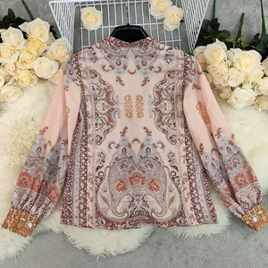 Detailed view of bohemian printed blouse with intricate paisley patterns on peach fabric.