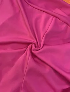 Detailed macro view showing the smooth texture and vibrant magenta color of the jumpsuit fabric