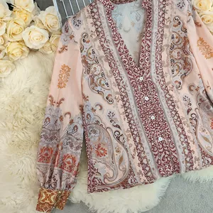 Close-up of bohemian paisley printed women's blouse with V-neck and puff sleeves detail