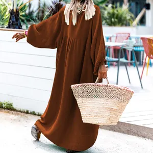 Back view of a loose rust-colored long vacation dress with textured fabric detail