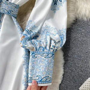 Vue détaillée du motif cachemire bleu et du poignet d'une robe chemise blanche à manches longues
