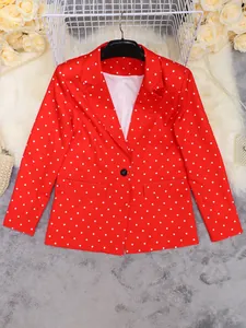 Detail view of vibrant red polka dot lapel blazer with button and pocket details