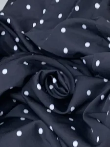 Close-up macro view of the black and white polka dot fabric texture for this blazer