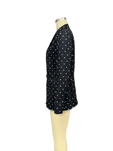Side view of elegant black long sleeve blazer with white polka dots and notched lapel.