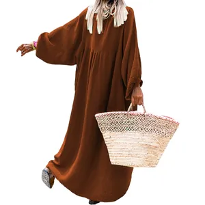 Back view of a loose brown long-sleeved maxi dress featuring textured fabric detail