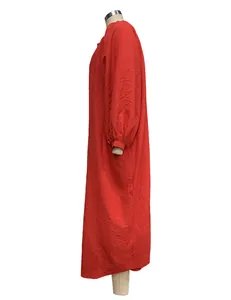 Side view of a vibrant red loose-fit maxi dress with long sleeves and textured fabric.
