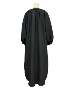 Back view of a black loose long-sleeve maxi dress on a display mannequin stand