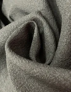 Detailed macro view of the charcoal grey woven fabric texture for a minimalist resort dress