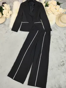 Detail view of black women's suit set with elegant white piping and wide-leg trousers