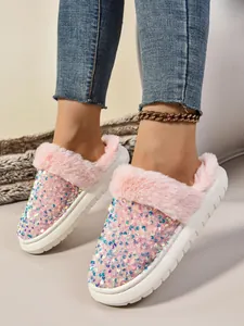 Detalle de pantuflas rosas con lentejuelas y piel sintética en los pies de una modelo.