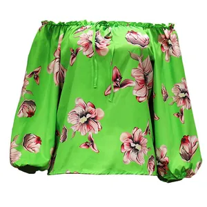 Close-up detail showing the green floral print off-shoulder blouse with drawstring neck
