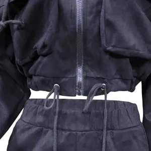 Close-up detail of a black cropped zip-up tracksuit with drawstring waist