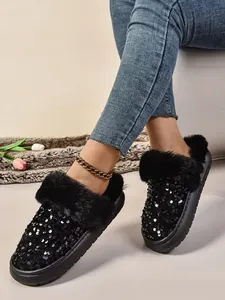 Primer plano de pantuflas de lentejuelas negras con forro de piel sintética suave