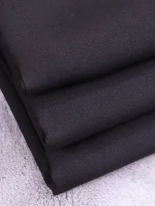 Gedetailleerde close-up van zwarte dikke pakstof met een verfijnde kepertextuur.