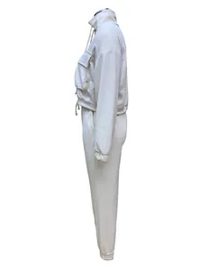 Detailed side view of women's cream two-piece cropped tracksuit with joggers and pockets