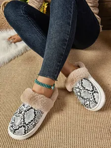 Detalle de zapatillas con estampado de serpiente, cuello de felpa y suela blanca gruesa