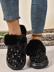 Primer plano de lentejuelas negras y piel sintética en pantuflas de plataforma de invierno