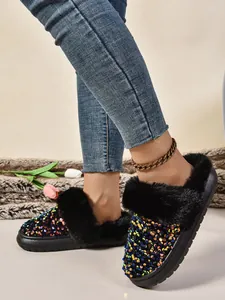 Primer plano de pantuflas de plataforma con lentejuelas negras y ribete de pelo sintético