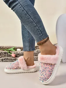 Detalle de estilo de vida de pantuflas de felpa con lentejuelas rosas y suela de plataforma.