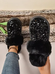 Primer plano de pantuflas de plataforma con lentejuelas negras y ribete de piel sintética gruesa.