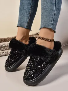Detalle de pantuflas negras con lentejuelas para mujer con suelas gruesas y piel sintética