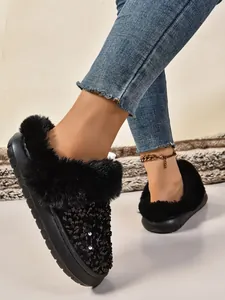 Detalle de zapatillas con lentejuelas negras y ribete grueso de piel sintética en pies.