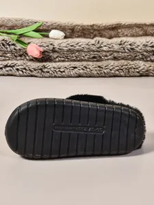 Primer plano de la suela de goma antideslizante de las pantuflas de invierno de felpa negra