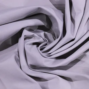 Close-up macro detail showing the smooth texture of lavender fabric for a trench coat