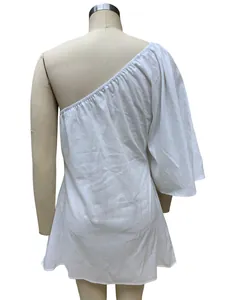 Detailed back view of a stylish white one-shoulder cotton linen dress on a dress form.
