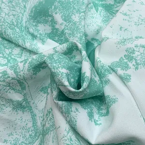 Close-up detail of mint green toile de Jouy printed fabric with elegant tree patterns