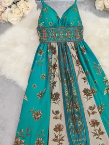 Detail shot of a vintage floral maxi dress with teal and beige patterns.