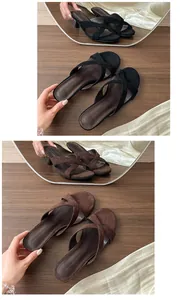 Dettaglio di sandali minimalisti con cinturini incrociati in nero e marrone scuro
