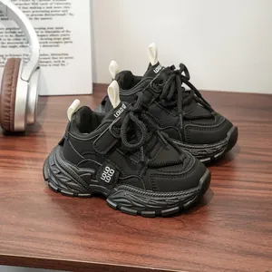 Vue détaillée de baskets chunky noires élégantes pour enfants sur une table en bois