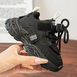 Vue latérale de baskets de sport noires pour enfants à semelle épaisse